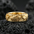 Load image into Gallery viewer, Gold plated wolf and deer wildlife band on volcanic rock, raised animal relief with bold contrast and refined shine, luxury studio macro.