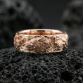 Load image into Gallery viewer, Rose gold plated wolf and deer band ring on black volcanic stone, detailed sculpted heads with warm metallic highlights, elegant product close-up.