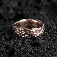 Load image into Gallery viewer, Rose gold plated hammered texture band on black volcanic stone, organic rocky relief with soft warm shine, luxury product photo.