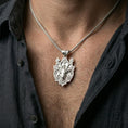 Load image into Gallery viewer, Polished silver stag necklace with sculpted deer face and botanical antler details worn on the neck in a close lifestyle frame, highlighting the woodland artistry and intricate relief