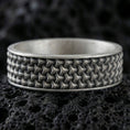 Load image into Gallery viewer, Oxidized sterling silver woven-grid texture band ring on black volcanic rock, deep shadowed recesses emphasizing the geometric pattern, macro product photo.