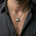 Load image into Gallery viewer, Polished silver bull necklace worn on the neck in a close lifestyle frame, highlighting the sculpted body detail and dynamic animal silhouette