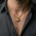 Load image into Gallery viewer, Gold plated bull pendant with muscular zodiac-inspired design worn on the neck in a premium lifestyle composition with strong symbolic jewelry styling