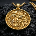 Load image into Gallery viewer, Gold plated koi fish pendant with detailed fish relief, blooming lotus motifs, and elegant round medallion form showcased on black volcanic rock in a refined macro jewelry image
