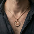 Load image into Gallery viewer, Rose gold plated lotus pond necklace with sculpted koi fish relief, floral aquatic motif, and round medallion form worn on the neck in a refined lifestyle shot with a warm and sophisticated presentation