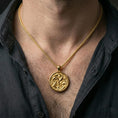 Load image into Gallery viewer, Gold plated koi fish pendant with lotus flower detailing and circular pond scene worn on the neck in a premium lifestyle composition with elegant marine-inspired jewelry styling