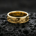 Load image into Gallery viewer, Gold plated minimalist floral scroll ring on black volcanic stone, warm reflective finish highlighting the engraved vine and swirl ornament.