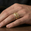 Load image into Gallery viewer, Gold plated Celtic knot iron cross band ring worn on finger, rich warm shine defining the braided border and raised centerpiece.