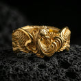 Load image into Gallery viewer, Rooster motif ring displayed on volcanic rock with a gold plated finish, bringing out the layered feather texture and raised centerpiece.