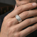 Load image into Gallery viewer, Polished silver fleur de lis band ring on a finger, clean shine with crisp engraved fleur symbols and geometric accents.