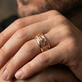 Load image into Gallery viewer, Rose gold plated wolf pack spinner ring on a finger, elegant metallic glow with detailed wolves and a comfort-fit style.