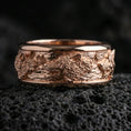 Load image into Gallery viewer, Wolf pack spinner band on volcanic stone with a rose gold plated look, showing the sculpted wolves and smooth rounded edges.