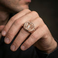 Load image into Gallery viewer, A rose gold plated Perseus and Medusa ring worn on the finger, luxury myth-inspired statement ring with raised details.
