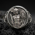Load image into Gallery viewer, A 925 sterling silver Perseus and Medusa ring on black volcanic stone, oxidized contrast showing the myth relief scene.