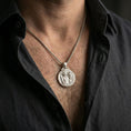 Load image into Gallery viewer, A polished 925 sterling silver Greek mythology coin pendant worn on the neck, bold medallion style on a chain.