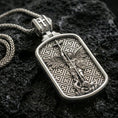 Load image into Gallery viewer, 925 sterling silver Saint Michael dog tag necklace on volcanic rock with a clean polished shine highlighting the border and relief.
