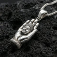 Load image into Gallery viewer, 925 sterling silver Buddha hand pendant on volcanic rock with a clean polished shine highlighting the serene face and hand contours.