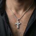 Load image into Gallery viewer, Polished silver floral cross pendant worn on the neck in a close lifestyle frame, highlighting the engraved rose details and classic silhouette