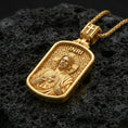 Load image into Gallery viewer, Gold plated Christian pendant with Sacred Heart Jesus design, detailed relief, and INRI lettering showcased on black volcanic rock in a refined macro jewelry image
