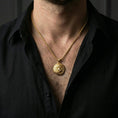Load image into Gallery viewer, Gold plated tiger pendant with curled wild cat silhouette, engraved stripe detailing, and jungle-inspired symbolism worn on the neck in a premium lifestyle composition with elegant animal jewelry styling
