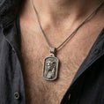 Load image into Gallery viewer, Oxidized Jesus pendant with shepherd staff worn on the neck in a lifestyle jewelry shot, styled against the chest for a bold and devotional look