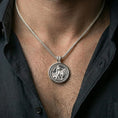 Load image into Gallery viewer, Polished silver Lion of Judah medallion pendant worn on the neck in a close lifestyle frame, highlighting the circular spinner design and detailed lion relief