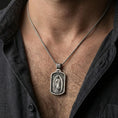 Load image into Gallery viewer, Oxidized Our Lady of Guadalupe pendant worn on the neck in a lifestyle jewelry shot, styled against the chest for a devotional and timeless look