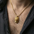 Load image into Gallery viewer, Gold plated polygonal wolf pendant with sharp geometric wolf face, faceted modern design, and spirit animal symbolism worn on the neck in a premium lifestyle composition with bold animal-inspired jewelry styling