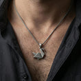 Load image into Gallery viewer, Oxidized origami swan pendant with minimalist geometric bird silhouette worn on the neck in a lifestyle jewelry shot, styled against the chest for a modern and artistic statement look