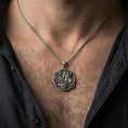 Load image into Gallery viewer, Oxidized Saint George pendant with dragon slayer design worn on the neck in a lifestyle jewelry shot, styled against the chest for a bold and symbolic look