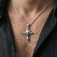 Load image into Gallery viewer, Polished silver skull cross necklace worn on the neck in a close lifestyle frame, highlighting the gothic relief details and dramatic cross design