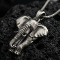 Load image into Gallery viewer, Sterling silver elephant pendant necklace with an oxidized finish resting on textured volcanic rock, captured in a close-up premium studio composition.