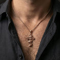 Load image into Gallery viewer, Rose gold plated ornate Christian cross pendant with filigree pattern and engraved text worn on the neck in a refined lifestyle shot with a warm and distinctive presentation