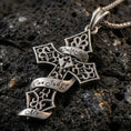 Load image into Gallery viewer, Oxidized gothic cross pendant with ornate filigree details and Only God Can Judge Me inscription displayed on dark volcanic rock in a close-up luxury jewelry composition