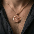 Load image into Gallery viewer, Rose gold plated Saint George pendant with horse rider relief and circular medallion form worn on the neck in a refined lifestyle shot with a warm and powerful presentation