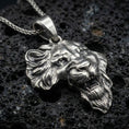 Load image into Gallery viewer, Sterling silver lion head pendant necklace with an oxidized finish resting on textured volcanic rock, captured in a close-up premium studio composition.