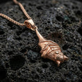 Load image into Gallery viewer, Rose gold plated hanging bat pendant necklace on dark volcanic rock, photographed in a detailed premium studio macro view.