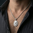 Load image into Gallery viewer, Polished silver Virgin Mary medal with star halo and sacred heart detail worn on the neck in a close lifestyle frame, highlighting the refined religious relief and oval silhouette
