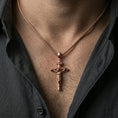 Load image into Gallery viewer, Rose gold plated Jesus cross pendant with sculpted corpus and INRI inscription worn on the neck in a refined lifestyle shot with a warm and elegant presentation