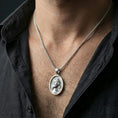 Load image into Gallery viewer, Polished silver Jesus medal with sacred portrait and crown of thorns worn on the neck in a close lifestyle frame, highlighting the refined facial relief and oval design