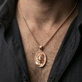Load image into Gallery viewer, Rose gold plated religious Jesus medal with sacred portrait relief worn on the neck in a refined lifestyle shot with a warm and elegant presentation