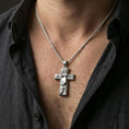 Load image into Gallery viewer, Polished silver Christian cross pendant with detailed Christ relief worn on the neck in a close lifestyle frame, highlighting the sculpted figure and classic sacred design