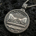 Load image into Gallery viewer, Oxidized Last Supper pendant with Pray for Us inscription, detailed round medallion design, and two-sided devotional concept displayed on dark volcanic rock in a close-up luxury jewelry composition