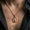 Load image into Gallery viewer, Rose gold plated oval Sacred Heart pendant with refined devotional detail worn on the neck in a refined lifestyle shot with a warm and elegant presentation