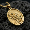 Load image into Gallery viewer, Gold plated Saint Christopher pendant with traveler saint motif, oval medallion form, and sacred portrait detail showcased on black volcanic rock in a refined macro jewelry image