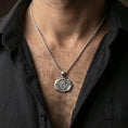 Load image into Gallery viewer, Polished silver chakra medallion with raised Om motif and symbolic lotus form worn on the neck in a close lifestyle frame, highlighting the sacred geometry and balanced design