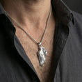 Load image into Gallery viewer, Polished silver wing necklace worn on the neck in a close lifestyle frame, highlighting the layered feather detailing and elegant celestial shape