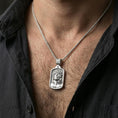 Load image into Gallery viewer, Polished silver Jesus medal with sacred portrait and crown of thorns worn on the neck in a close lifestyle frame, highlighting the detailed facial relief and framed silhouette