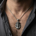 Load image into Gallery viewer, Oxidized Jesus Christ pendant with crown of thorns worn on the neck in a lifestyle jewelry shot, styled against the chest for a bold and devotional look