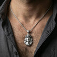 Load image into Gallery viewer, Polished silver Jesus pendant with sculpted sacred portrait and crown of thorns worn on the neck in a close lifestyle frame, highlighting the facial detail and religious symbolism